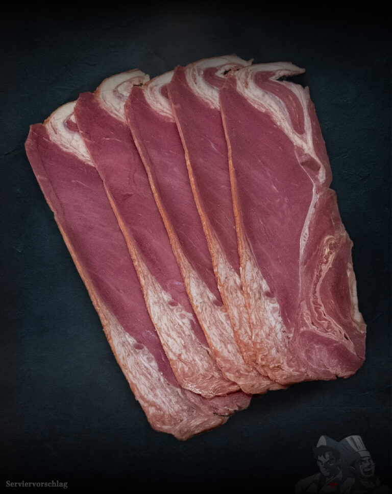 Beef Bacon Färse aus Pommern in frischen Scheiben auf dunklem Brett