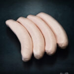 Saftige Berliner Currywurst mit Darm aus regionalem Schweinefleisch auf dunklem, edlem Untergrund