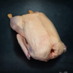 Gans aus Pommern Extra-Qualität roh, Premium-Geflügel vor metallischem Hintergrund