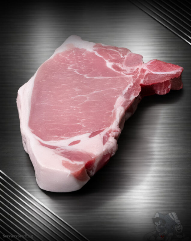 Rohes Kotelett vom regionalen Duroc-Schwein mit Knochen und feiner Marmorierung auf neutralem Untergrund.