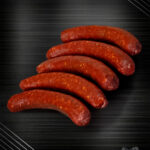 Merguez aus eigener Herstellung, heiß und würzig gegrillt über offener Glut