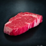 Rib Eye Steak Färse Pommern roh mit Fettauge auf Metalluntergrund