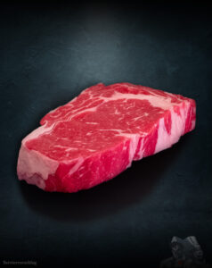 Rib Eye Steak Färse Pommern roh mit Fettauge auf Metalluntergrund