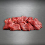 Rindergulasch aus Pommern roh, gewürfelt auf Edelstahluntergrund