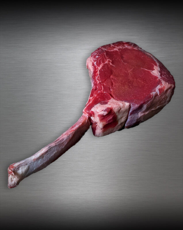 Saftiges Tomahawk Steak Färse vom Wolowina-Rind roh auf kühler Metallplatte