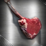 Saftiges Tomahawk Steak Färse vom Wolowina-Rind roh auf kühler Metallplatte