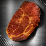 Rohes Duroc Schweinenackensteak mariniert mit feiner Marmorierung und pikanter Würzung auf neutralem Hintergrund.