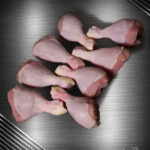 Rohe Prignitzer Chicken Drumsticks als Hähnchenunterkeulen mit Knochen auf neutralem Untergrund.