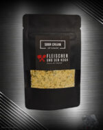 Sour Cream Onion Dip, umgeben von Kräutern und Zwiebelstücken