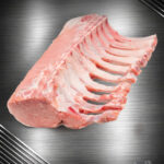 Rohes Schweinekarree vom regionalen Strohschwein am Knochen auf neutralem Hintergrund