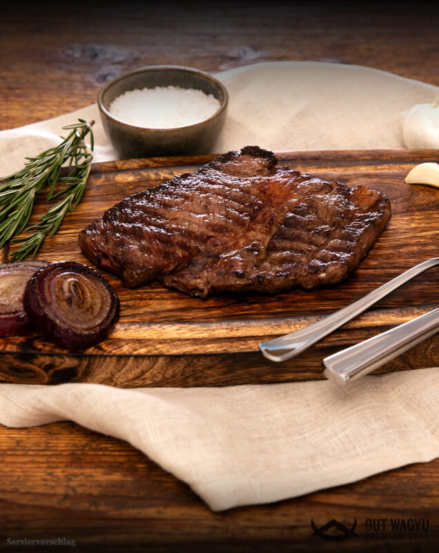 Zubereitetes Wagyu Prime Rib aus Deutschland in Scheiben auf rustikalem Holzbrett