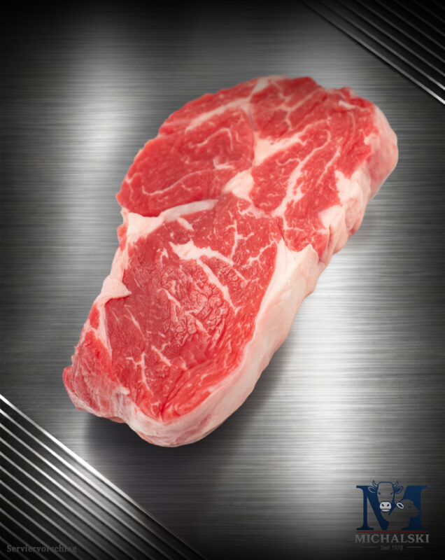 Michalski Ribeye Steak von der Weidefärse roh mit sichtbarer feiner Fettmarmorierung an der Seite
