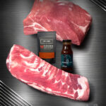 Smoker Bundle mit Duroc Schweinenacken und St Louis Ribs roh auf dunklem Hintergrund