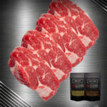 Steakhouse Bundle mit rohen Ribeye Steaks von der deutschen Weidefärse und Gewürzen auf dunklem Hintergrund