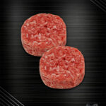 Zwei deutsche Wagyu Smashburger Patties nach Haché-Art mit grober Fleischstruktur auf dunklem Hintergrund