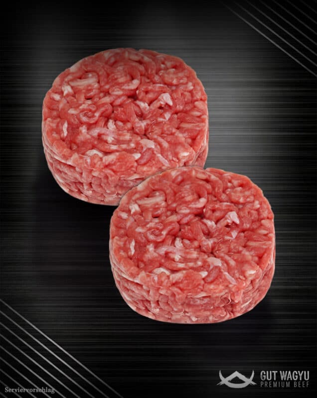Zwei rohe, runde Deutsche Wagyu Smashburger Patties nach Haché-Art mit grober Fleischstruktur auf dunklem Hintergrund.