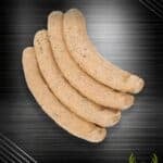 Wildweisswurst aus regionaler Jagt mit sichtbarer Petersilie auf dunklem Hintergrund.